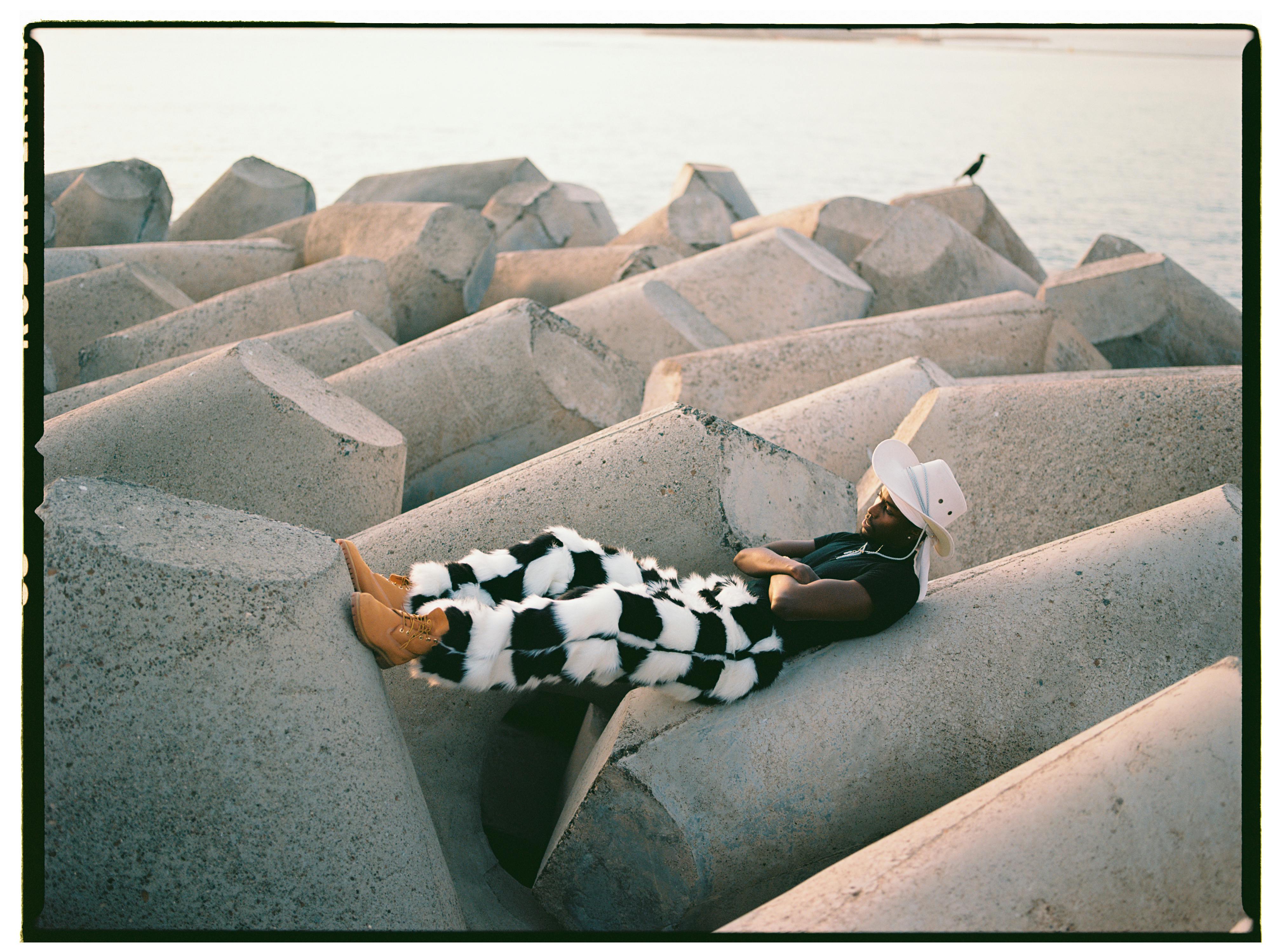 man lying on some rocks in a fun outfit